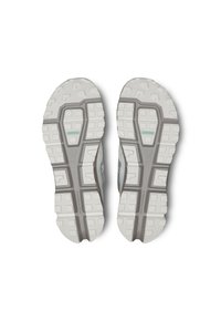 Suole di scarpe atletiche leggere, caratterizzate da gomma grigia testurizzata con motivi di trazione bianchi e un design centrale per stabilità e supporto.