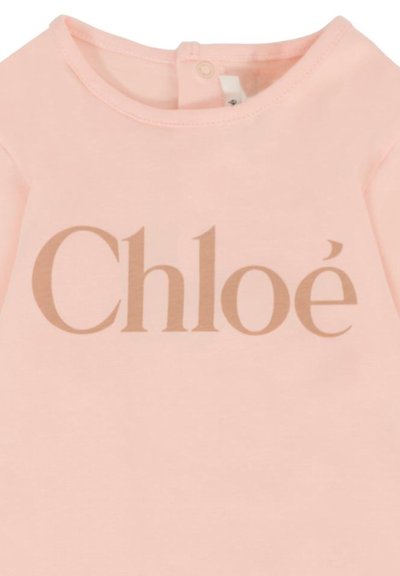 Camicia di cotone rosa con un grande logo beige "Chloé". Il design include un collo rotondo con chiusura a bottone sul retro.