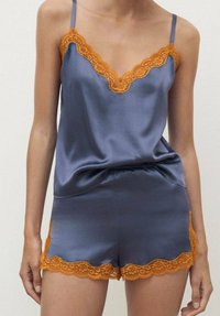 Set di pigiama in raso blu navy con rifiniture in pizzo arancione sul collo e sull'orlo, dotato di spalline regolabili e di una vestibilità comoda.