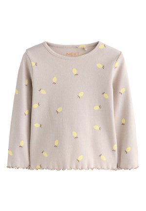 Világos bézs színű bordás hosszú ujjú ing, kis sárga gyümölcsmintákkal és fodrozott szegéllyel, gyermekeknek tervezve.