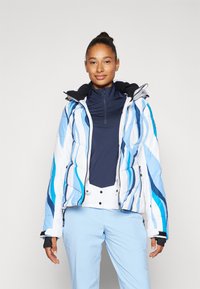 Gepolsterte Winterjacke in Weiß mit blauen Wellenmustern, ausgestattet mit einem Reißverschluss, einer verstellbaren Kapuze und elastischen Bündchen. Kombiniert mit einem marineblauen Oberteil.