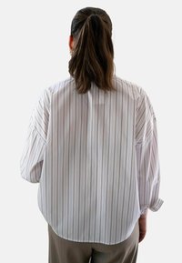 Lange mouwen shirt van lichtgewicht stof, wit met verticale lichtbruine strepen, met een relaxte pasvorm en afgezakte schouders.