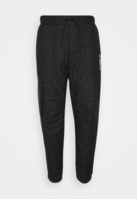 Svarta kviltade byxor med dragsko i midjan, elastiska ärmslut och detaljmönster. Har en liten vit logotyp på sidan.