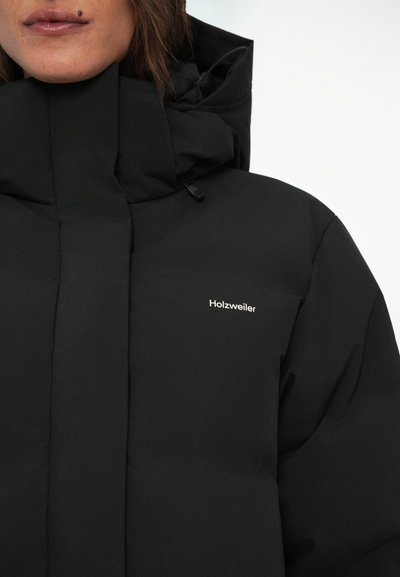Zwarte pufferjack met hoge kraag, voorzien van een ritssluiting en een klein wit logo. Het materiaal lijkt glad en mat.