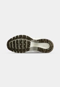 Sole of a Nike sneaker with black and white tread, featuring rectangular and circular grip patterns and the "NIKE" logo near the heel.