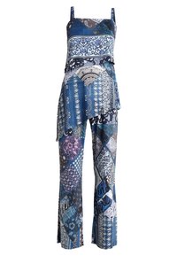 Haut sans manches à motifs bleu assorti avec un ourlet asymétrique et un pantalon large présentant des motifs floraux et géométriques en patchwork.