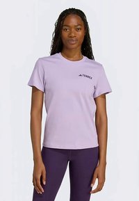 Light purple short-sleeve T-shirt with a round neckline and TERREX logo in black on the left chest. Soft, smooth fabric texture.