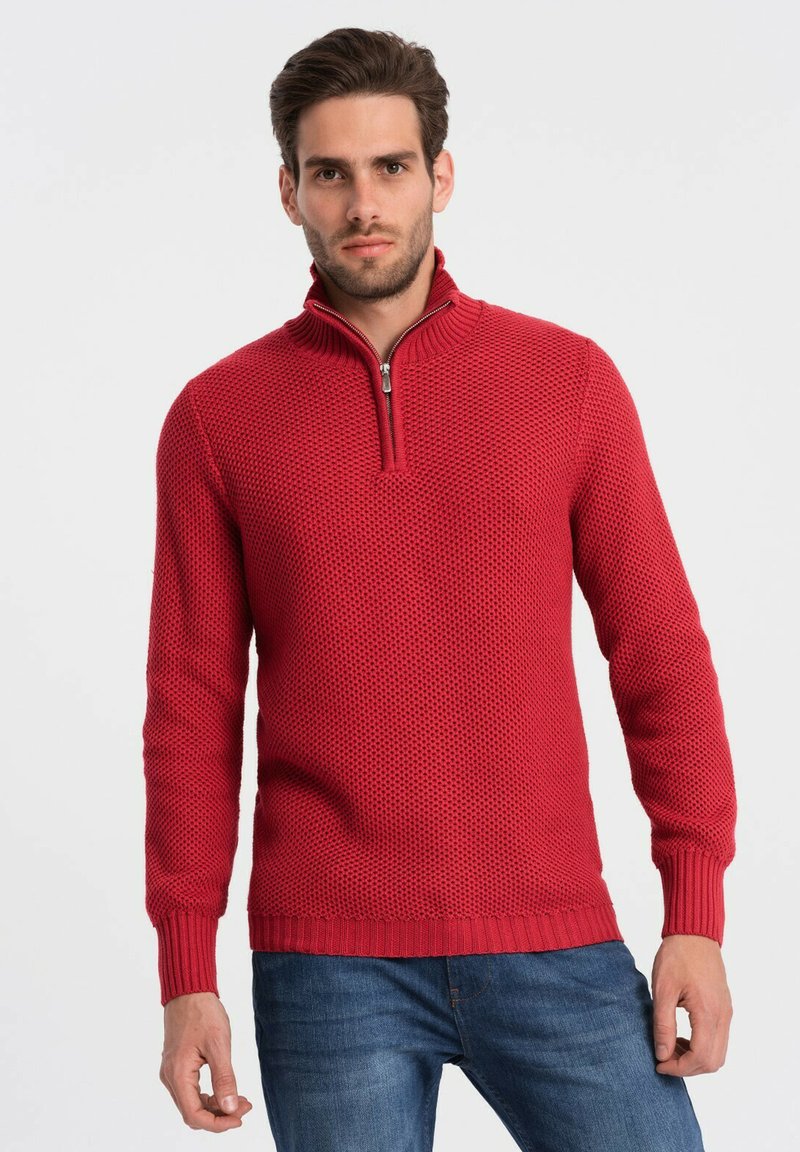 Rode gebreide trui met een gestructureerd patroon, halve rits-kraag en geribde manchetten en zoom. Gemaakt in combinatie met blauwe jeans, is het ontwerp casual en aansluitend.