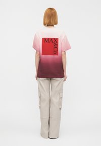 Κοντομάνικο T-shirt με διαβάθμιση από ροζ σε μπορντό, με κόκκινο τετράγωνο σχέδιο που γράφει «MAX & Co.» Μαύρα γράμματα πάνω σε μια διακριτική υφή.