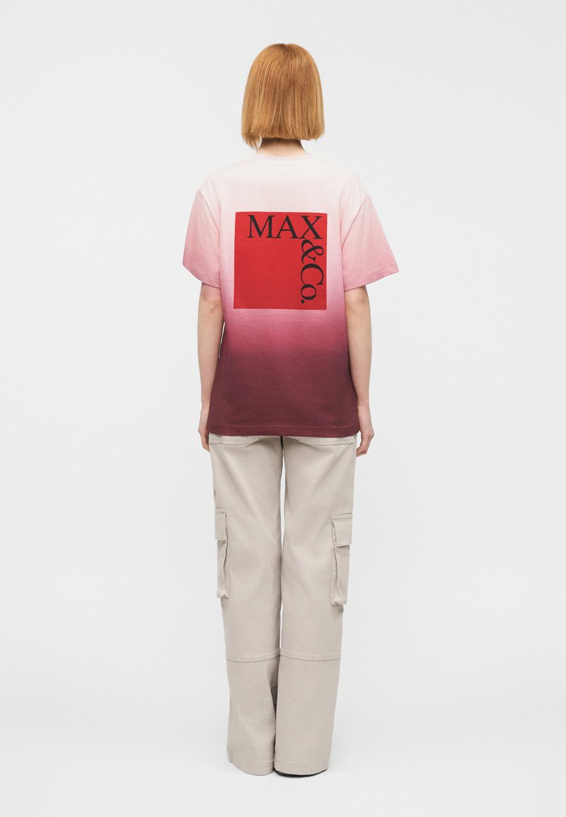 Κοντομάνικο T-shirt με διαβάθμιση από ροζ σε μπορντό, με κόκκινο τετράγωνο σχέδιο που γράφει «MAX & Co.» Μαύρα γράμματα πάνω σε μια διακριτική υφή.