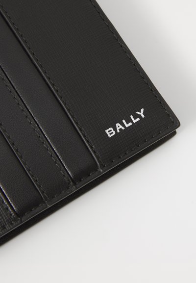 Svart lærpung med teksturert overflate, med flere kortlommer og preget "BALLY"-logo i hvitt.