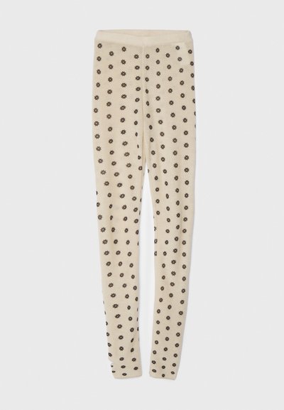 Leggings beige con una texture morbida, caratterizzati da un motivo a fiori piccoli e scuri su tutta la superficie. Vita elastica per una vestibilità confortevole.