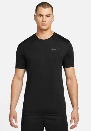 T-shirt desportivo preto feito de tecido leve. Apresenta mangas curtas e gola redonda. Design texturizado nos ombros. Logótipo da Nike em cinza.