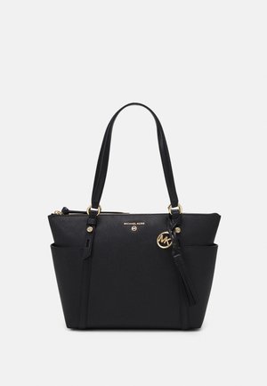 Sac tote en cuir noir avec double poignée, poches latérales, logo Michael Kors doré et un charm MK doré avec un pompon.