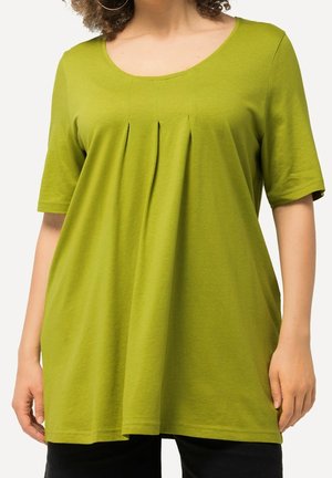 Koszulka z krótkim rękawem w żywym zielonym kolorze z bawełny. Posiada okrągły dekolt i fałdy poniżej biustu, co zapewnia luźny krój i zwiewność.