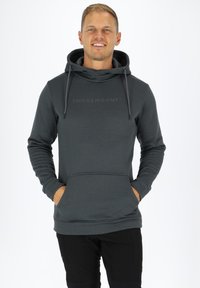 Felpa con cappuccio grigio scuro, dotata di tasca frontale, lacci e un sottile logo "SWEDEMOUNT" sul petto. Texture liscia, design informale.