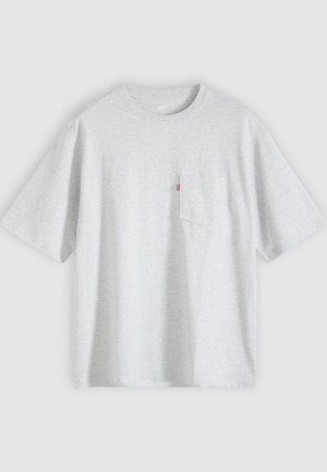 T-shirt gris clair à manches courtes avec un col rond et une petite poche poitrine sur le côté gauche avec une étiquette rouge.
