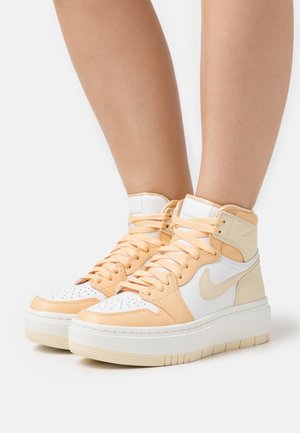 High-top sneakers in white, light peach, and beige leather with perforated toe box, padded collar, and textured sole. Laced closure.