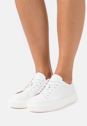 Białe skórzane sneakersy o niskim profilu, z okrągłym noskiem, minimalistycznym sznurowaniem i teksturowaną gumową podeszwą.