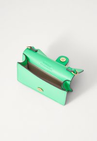 Portofel verde din piele, cu o textură netedă, având accesorii aurii, închidere cu buton și un compartiment deschis care evidențiază interiorul.
