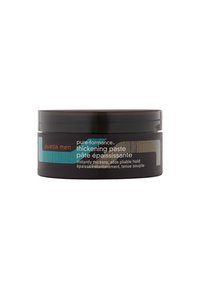 Conteneur noir de pâte épaississante Aveda Men avec une étiquette teal et argent, présentant un texte en gras et une bande texturée, de forme ronde et finition mate.