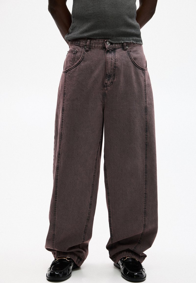 Jeans a gamba larga di un colore mauve scolorito, realizzati in denim con cuciture visibili, dotati di due tasche frontali e chiusura con bottone.