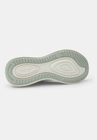 Suola di una scarpa realizzata in materiale gommoso, con un design aerodinamico, colori beige chiaro e verde menta, e motivi testurizzati sulla suola per una migliore aderenza.