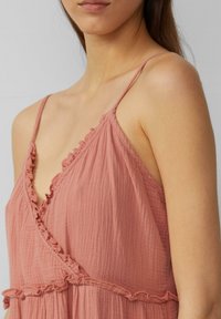 Staubrosa, leichtes Kleid mit Rü Schmidt Kragen und dünnen Trägern; besteht aus einem strukturierten Stoff und hat ein Wickeldesign.