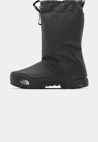 Botas negras de invierno con parte superior acolchada, suela de goma resistente y parte superior texturizada. Presenta un cierre con cordón y la marca Vibram en la suela.