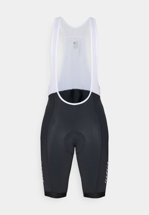 Zwarte fiets-bibshorts met witte netstof schouderbanden, een gepolsterd zitgedeelte en een logodetail op het been. Glad materiaal met een aansluitend ontwerp.