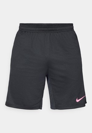 Črne športne hlače iz teksturirane tkanine, z elastičnim pasom in roza Nike swoosh logotipom na spodnjem levem delu.