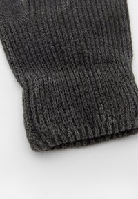 Harmaa neulottu kukka, jossa on ribbikuvio ja vaihtelevaa harmaan sävyä, tiukka istuvuus ranteessa lämmön ja mukavuuden takaamiseksi.