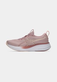 Light pink athletic shoe with mesh upper, gold accents, cushioning sole, and a pronounced heel. Features a pull tab on the back.