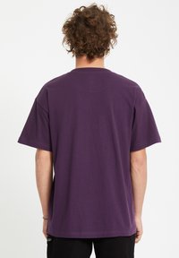 Paarse katoenen t-shirt met korte mouwen en een relaxte pasvorm. Glide structuur, ronde halslijn en geen zichtbare patronen of graphics op de achterkant.