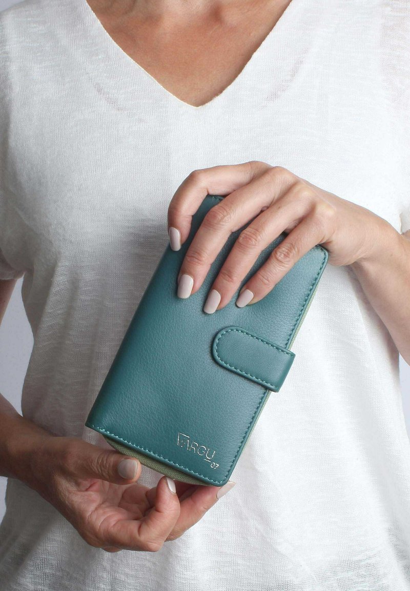 Teal leather wallet with a flap closure, featuring a textured surface, sewn edges, and a metallic logo at the bottom.
