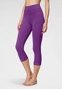Vijolične legice kapri iz raztegljivega materiala, z širokim pasom in oprijetim krojem. Gladek teksturni videz brez vidnih vzorcev.