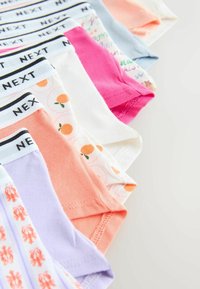 Culottes pour filles colorées assorties avec des motifs d'oranges, de homards, et des couleurs unies, chacune dotée d'une ceinture blanche marquée "NEXT".