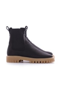 Botas Chelsea negras hechas de tela texturizada, con una suela de goma gruesa, paneles laterales elásticos y lengüetas para facilitar su uso.