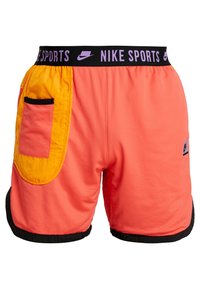 Shorts de sport Nike en mesh orange fluo, avec une taille élastique noire portant le texte "NIKE SPORTS" et un détail de poche jaune en contraste.