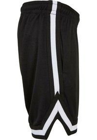 Black athletic shorts made of mesh material, featuring white side stripes, a tapered shape, and a contrasting angled hem.