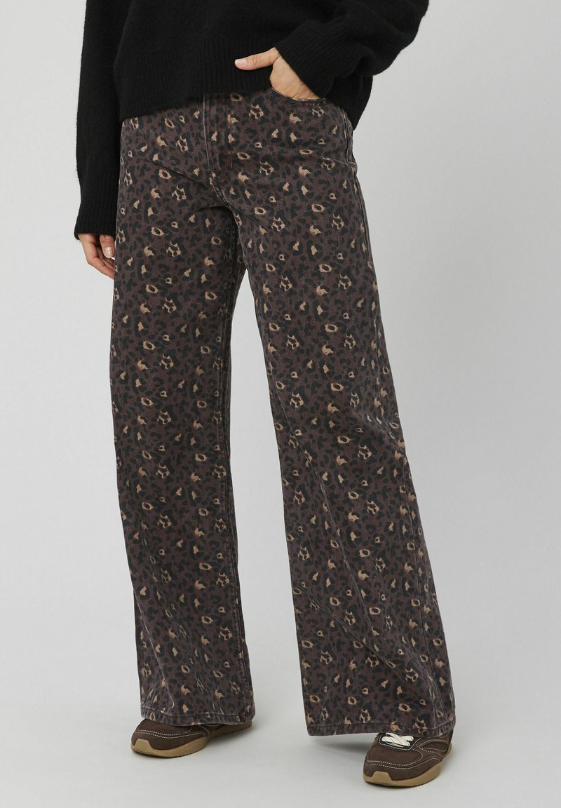 Pantalon à jambes larges imprimé léopard en marron foncé et beige, fabriqué en tissu texturé. Il présente une taille haute et des poches latérales pratiques.