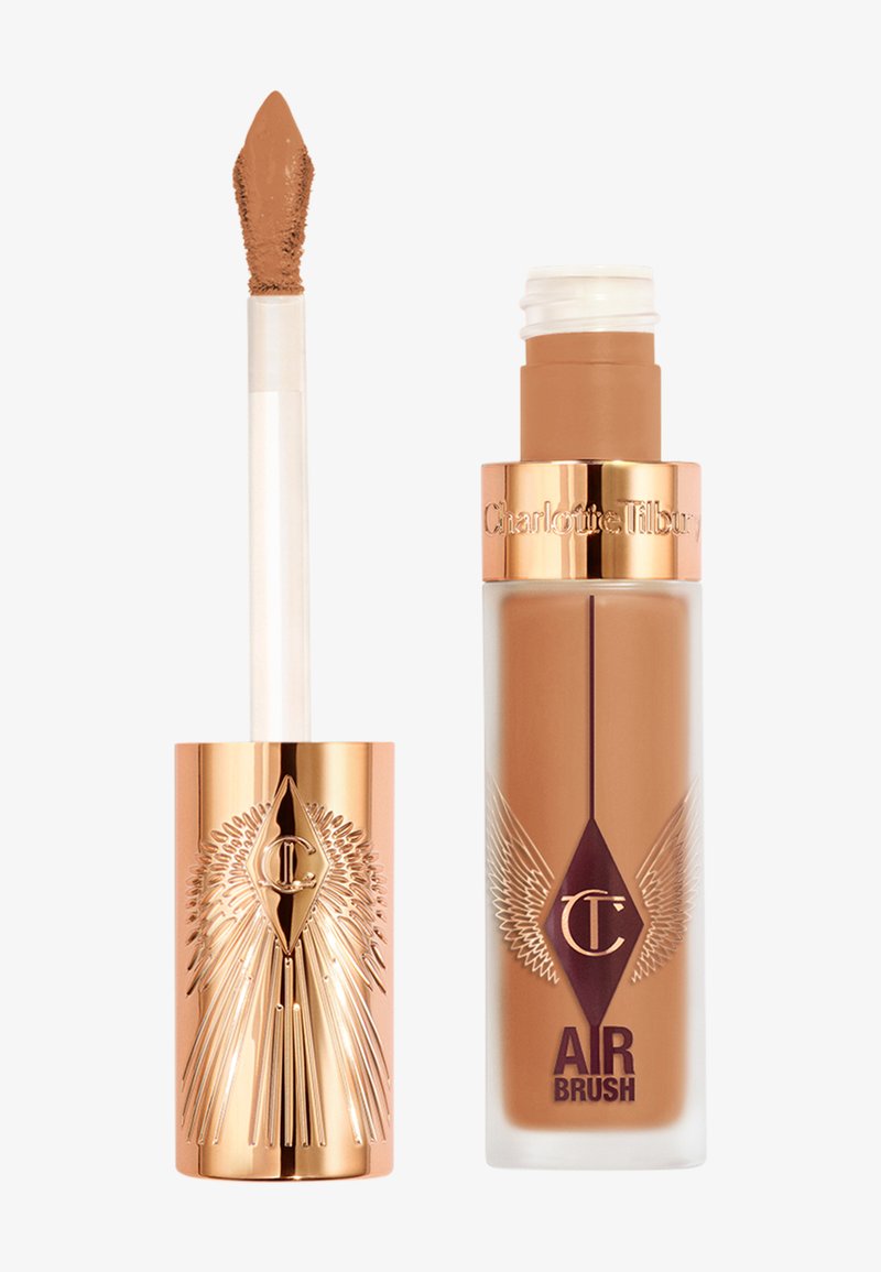 Fond de teint liquide dans un flacon en verre transparent avec des accents dorés et violets. Comprend un applicateur mousse avec une formule lisse de couleur marron.
