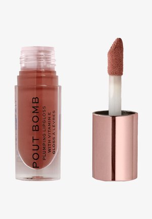Lucidalabbra volumizzante in contenitore trasparente con accenti in rosso oro. L'applicatore ha una punta morbida e felpata. Il colore è una tonalità nude tenue.