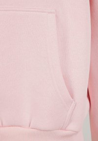 Rosa sweatshirt med en myk tekstur, ribbestrikket nederkant og en frontlomme med et rent design. Stoffet virker glatt med minimale sømdetaljer.