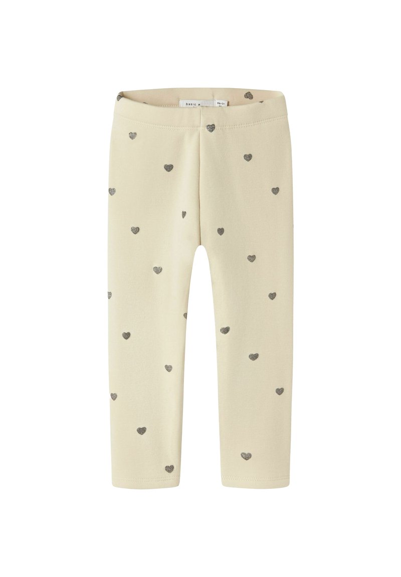Krém színű bébi leggings, apró ezüst szívmintákkal, rugalmas derékrésszel és hosszú lábakkal.