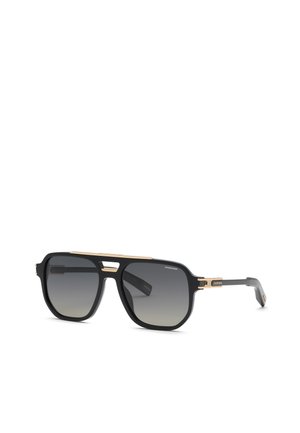 Lunettes de soleil style aviateur noires et dorées avec verres sombres dégradés et un fin détail de pont doré sur fond blanc.