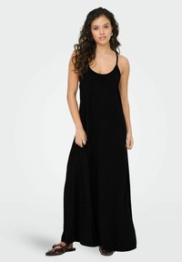 Robe maxi noire à fines bretelles, décolleté arrondi et silhouette fluide, fabriquée en tissu léger, avec une coupe décontractée.