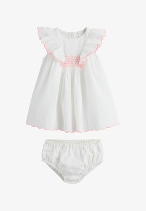 Vestitino bianco senza maniche per bebè con colletto arricciato, bordi rosa smerlati, corpino arricciato, abbinato a pantaloni bianchi elastici a vita alta.