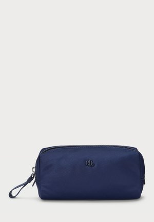 Necessaire azul marinho em tecido texturizado com fecho de zipper, apresentando um pequeno logotipo na parte da frente e uma alça para pulso de um lado.