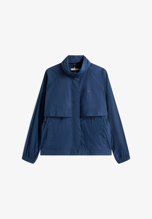 Giacca a vento blu navy realizzata in tessuto leggero, dotata di colletto alto, due tasche frontali e polsini elasticizzati per una vestibilità sicura.